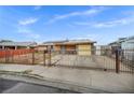 Single-story house with a wrought iron fence, rock landscaping, and solar panels on the roof at 54 Del Amo Dr, Las Vegas, NV 89110