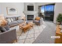 Staged living room with modern furniture, a fireplace and large sliding doors to a sunny patio at 5415 W Harmon Ave # 2048, Las Vegas, NV 89103