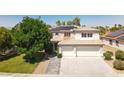 Lovely home exterior featuring a spacious driveway, lush lawn, mature trees, and desert landscaping at 6313 Giant Oak St, North Las Vegas, NV 89084