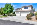 Attractive exterior view of home with large driveway, beautiful landscaping, and a well-maintained lawn at 6313 Giant Oak St, North Las Vegas, NV 89084