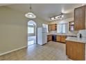 Cozy kitchen features tile floors, appliances, wood cabinets, and an open layout into the living area at 6381 Pronghorn Ridge Ave, Las Vegas, NV 89122