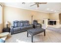 Spacious living room featuring a tile floor, a ceiling fan, and a comfortable seating area at 7491 Speedwell Cavern St, Las Vegas, NV 89139