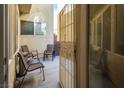 A cozy patio setting includes chairs and a trashcan on light colored paving at 7491 Speedwell Cavern St, Las Vegas, NV 89139
