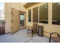 A comfortable patio setting includes chairs and a trashcan on light colored paving at 7491 Speedwell Cavern St, Las Vegas, NV 89139
