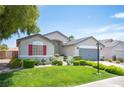 Attractive home with a green lawn, colorful flowers, and a neatly landscaped yard at 7500 Peaceful Brook St, Las Vegas, NV 89131