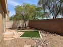 Backyard with artificial turf, rock landscaping, rock paths, and a privacy fence at 7788 Soda Canyon St, Las Vegas, NV 89139