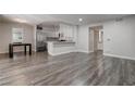 Open floor plan living room with wood flooring, breakfast bar and stainless refrigerator at 7905 Idledale Ct # 102, Las Vegas, NV 89145