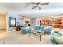 Open-concept living area with plush seating, staircase, and an adjacent kitchen at 8137 Cape Flattery Ave, Las Vegas, NV 89147