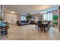 Spacious living room featuring tile flooring, a comfortable sectional sofa, and a dining area at 8137 Cape Flattery Ave, Las Vegas, NV 89147