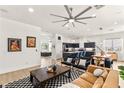 Spacious living area with ceiling fan, connected to modern kitchen with island and bar seating at 8317 Fritzen Ave, Las Vegas, NV 89131