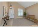 Inviting entryway with vaulted ceilings, stylish light fixture, console table and wooden bench seating at 9469 Coral Shine Ct, Las Vegas, NV 89123