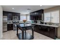 Modern kitchen featuring stainless steel appliances, dark wood cabinets, white countertops, and tile backsplash at 9469 Coral Shine Ct, Las Vegas, NV 89123