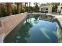 Sparkling swimming pool with tiled edge, complemented by mature landscaping and a relaxing sunbathing area at 10591 Haywood Dr, Las Vegas, NV 89135