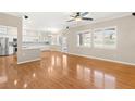 Open-concept living area with hardwood floors, large windows, and a view into the kitchen at 10712 Back Plains Dr, Las Vegas, NV 89134