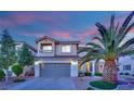 Charming two-story home featuring a well-manicured lawn, a two-car garage, and mature trees at 10902 Fintry Hills St, Las Vegas, NV 89141