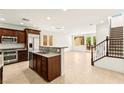Open floor plan featuring a modern kitchen with an island and a staircase at 1252 Casa Palermo Cir, Henderson, NV 89011