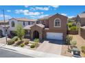 Charming house with stone accents, arched entryway, two-car garage, and attractive landscaping at 133 Clouded Ave, Henderson, NV 89002
