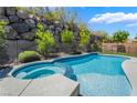 Sparkling pool and spa with a rock wall surround offer a private backyard retreat at 133 Clouded Ave, Henderson, NV 89002