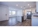 Open-concept kitchen with stainless steel appliances, island, and direct view to the living room at 145 Aqua Commons Ln, Henderson, NV 89015