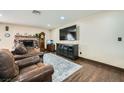 Comfortable living room with a brick fireplace, wood floors, and ample seating at 1491 Sunrise View Dr, Las Vegas, NV 89110
