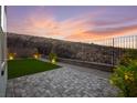 Backyard features a stone-paved area, lush landscaping, and a tranquil setting for outdoor enjoyment at 2004 Peaceful Mesa Ct, Henderson, NV 89052