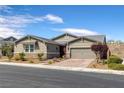Charming single-story home boasts desert landscaping, a two-car garage and a neutral color palette at 2489 Cingoli St, Henderson, NV 89044