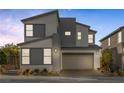 Modern two-story home featuring a gray exterior, attached garage, well-manicured landscaping, and a contemporary design at 2631 Chance Canyon St, Henderson, NV 89044