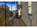 Charming walkway with brick pavers, decorative lighting, iron fencing and lush landscaping leading to the home's entrance at 2631 Chance Canyon St, Henderson, NV 89044