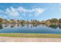 Picturesque lake view with manicured green lawn bordering the water, and clear reflection of the sky and homes at 3151 Soaring Gulls Dr # 1023, Las Vegas, NV 89128