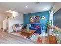 Cozy living room with a staircase, featuring contemporary furniture and a colorful rug at 48344 Orchid Ridge Ave # 104, Las Vegas, NV 89141