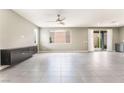 Spacious living room with large windows, tile flooring and dark built-in storage at 5981 Smith Valley Rd, Las Vegas, NV 89148