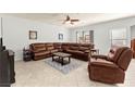 Comfortable living room with a large leather sectional sofa, ceiling fan, and neutral decor at 7641 Lani Dawn St, Las Vegas, NV 89149