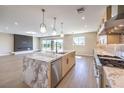 Modern kitchen with a large marble island, stainless steel appliances, and views of the living area at 8316 Broad Peak Dr, Las Vegas, NV 89131