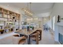 Open concept dining room with modern lighting, view of fireplace and bright kitchen with barstool seating at 9520 Sundial Dr, Las Vegas, NV 89134