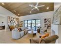 Bright living room featuring wood ceiling, open shelving, modern decor, and large windows to the backyard at 9520 Sundial Dr, Las Vegas, NV 89134