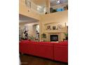 Inviting living room with a cozy fireplace, red sofa, and a view of the upper level landing at , Henderson, NV 89052