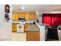 Bright kitchen with oak cabinets, granite counters, and an open layout to the dining area at 1259 Plum Canyon St, Las Vegas, NV 89142