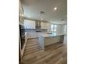 Modern kitchen with white cabinets, stainless steel appliances, and a center island with a sink at 1533 Bat Hawk St, Las Vegas, NV 89144
