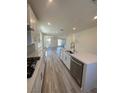Bright, open kitchen with white cabinetry, stainless appliances, and a view of the living area at 1533 Bat Hawk St, Las Vegas, NV 89144