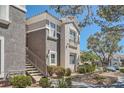 Exterior showcasing well-maintained landscaping, desert foliage, a private balcony, and neutral stucco at 2325 Windmill Pkwy # 312, Henderson, NV 89074