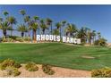 Rhodes Ranch community entrance with lush landscaping, palm trees, and a vibrant green lawn at 248 Windmill Croft Dr, Las Vegas, NV 89148