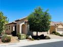 Single-story stucco home featuring desert landscaping, a barrel tile roof, and an arched entryway at 248 Windmill Croft Dr, Las Vegas, NV 89148