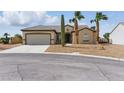 Single-story home with desert landscaping, including cactus and palm trees at 2612 Dearport Ct, Henderson, NV 89052