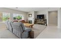 Bright, open-concept living room features neutral colors, a fireplace, and stylish furniture at 2612 Dearport Ct, Henderson, NV 89052