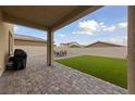 Covered patio featuring a barbecue, dining set, artificial grass and fenced perimeter at 2729 Pavehawk Way, Las Vegas, NV 89156