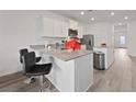 Modern kitchen featuring white cabinets, stainless steel appliances, a breakfast bar, and lots of countertop space at 2729 Pavehawk Way, Las Vegas, NV 89156