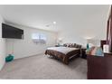 Bright primary bedroom with cozy carpet, a ceiling fan, and a window letting in natural light at 2729 Pavehawk Way, Las Vegas, NV 89156