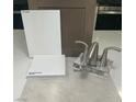 Sample materials showing modern bathroom faucet with matching bright quartz, white and grey tiling, and a neutral colored cabinet at 2775 Fantoni St, Henderson, NV 89044