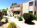 Two-story stucco condo with red tile roof and colorful desert landscaping on a sunny day at 3720 Desert Marina Dr # 33, Laughlin, NV 89029