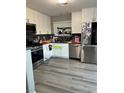 Bright kitchen with stainless steel appliances, white cabinets, and hardwood floors at 4363 Pittsfield St, Las Vegas, NV 89115
